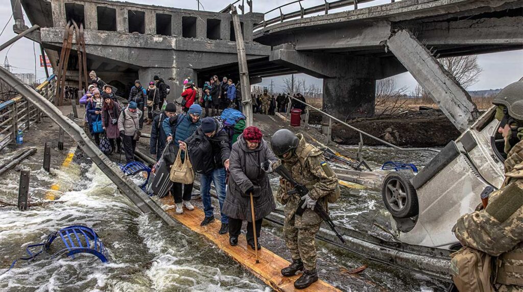 Le 7 mars 2022, ces personnes traversent un pont détruit, alors qu’elles fuient la ville d’Irpin, à 10 km de Kiev, la capitale de l’Ukraine.
