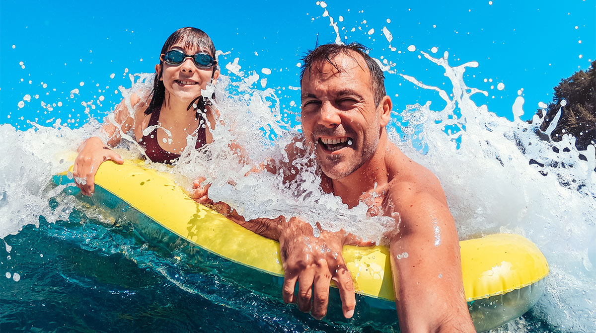 Un père et sa fille s'amusent dans l'eau.