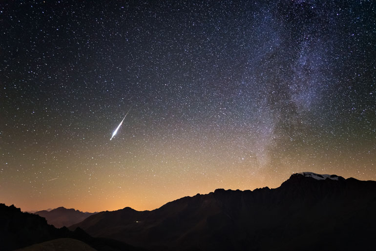 © Fabio Lamanna/Adobe Stock. Milky Way and starry sky from high up on the Alps. Real Christmas comet in the sky. Majestic high mountain range with glacier and snow.